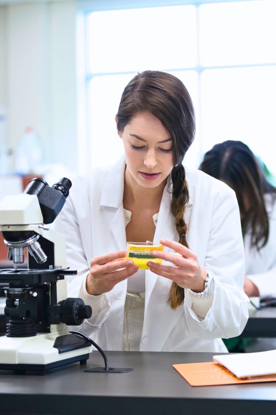 Students with microscopes in science lab at college campus