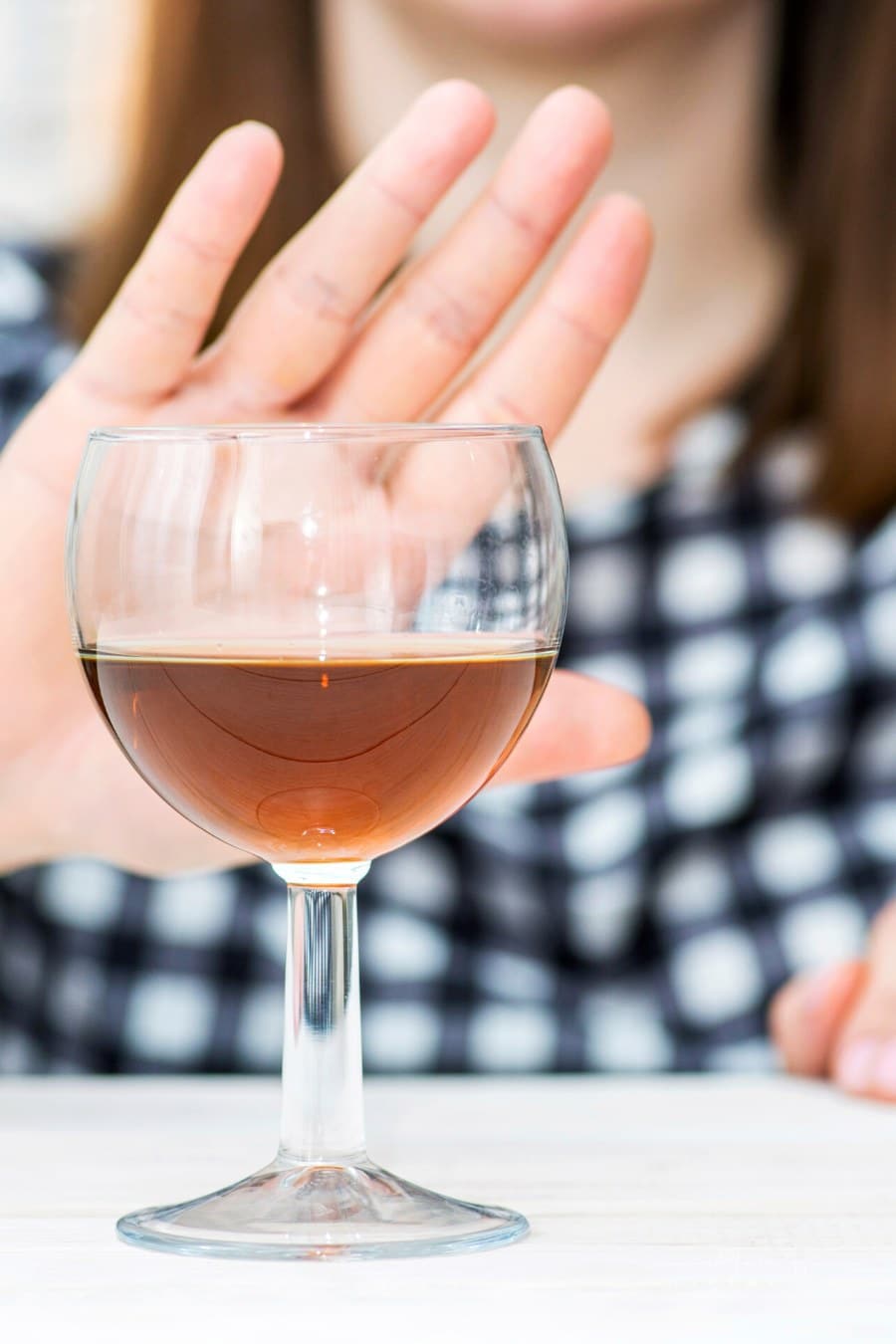 woman holding hand out pushing wine glass away