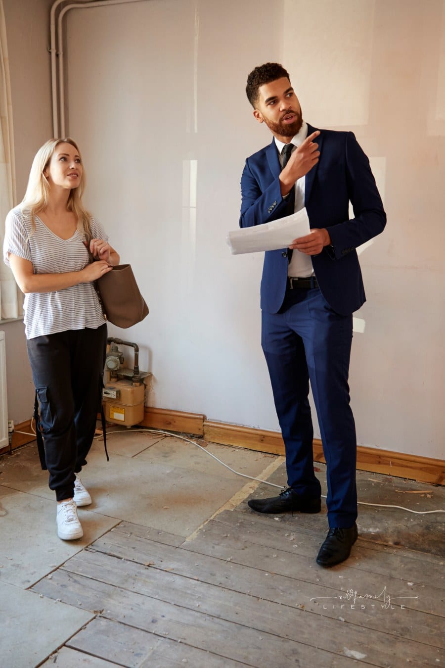 Woman looking at house in need of repair with realtor