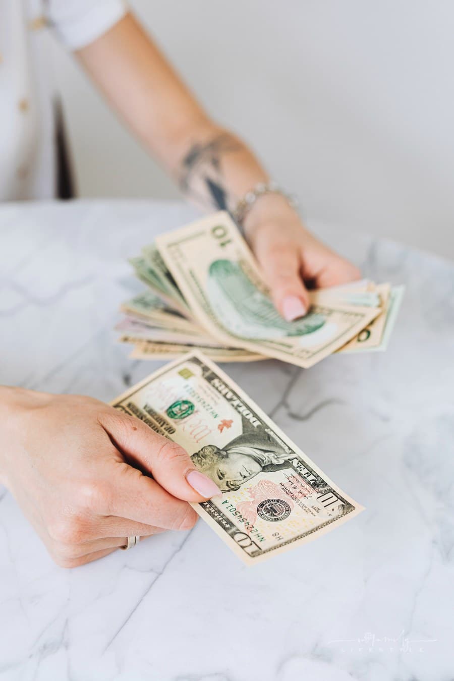 woman counting cash money over marble countertop