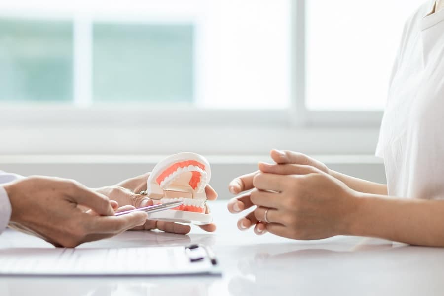 dentist showing tooth model to patient