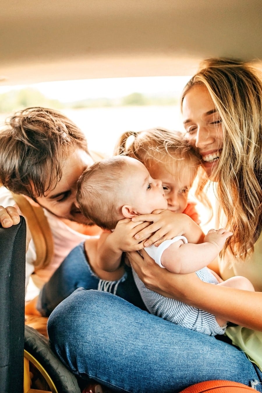 Young parents and happy kids having picnic in car