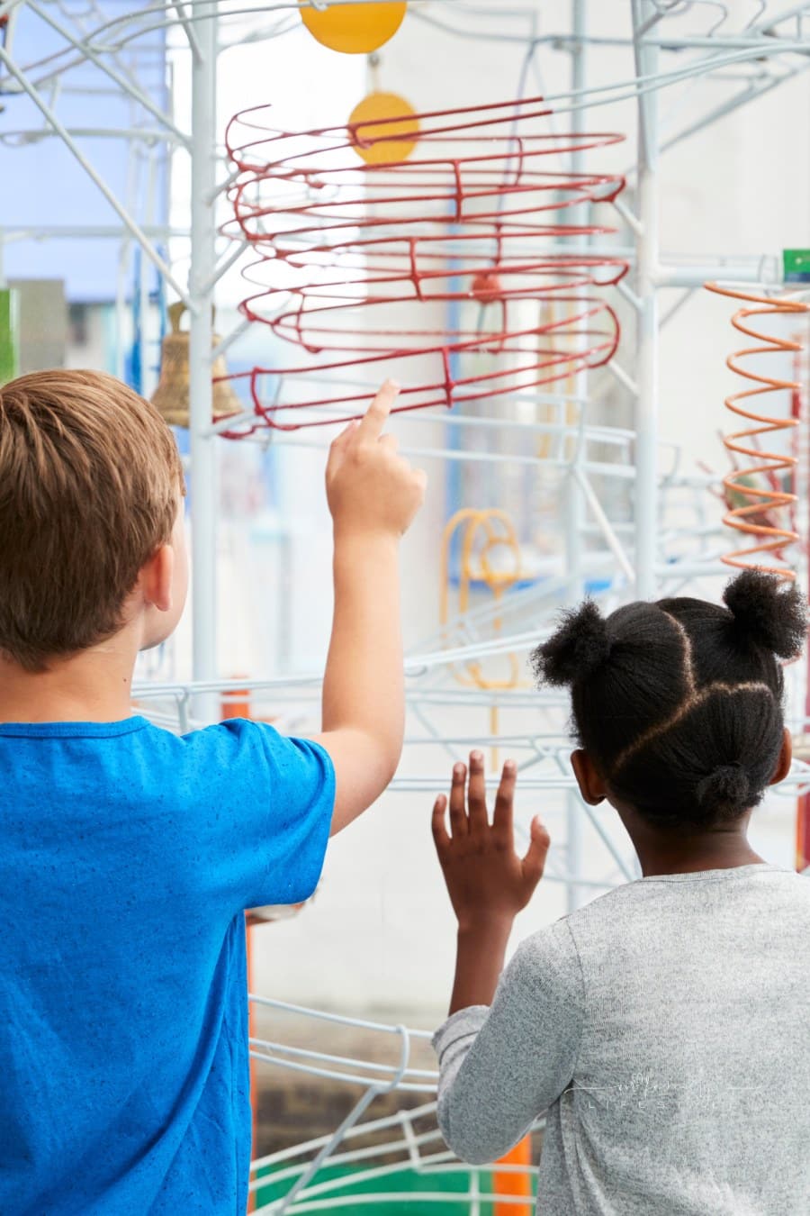 Two Kids Looking at a an interactive exhibit at a children's museum