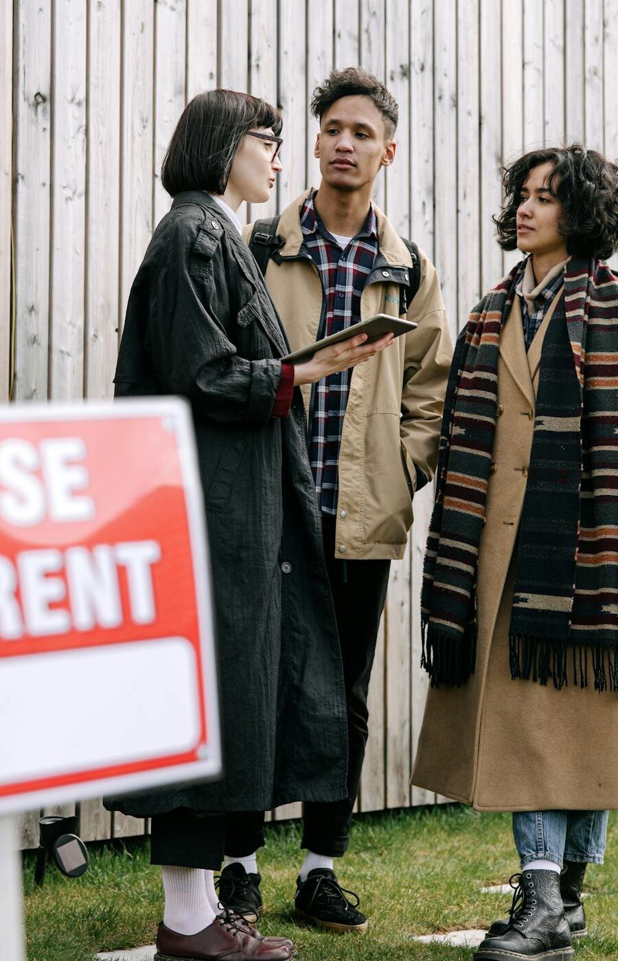 An interracial couple meets with a real estate agent to inquire about a house for rent.