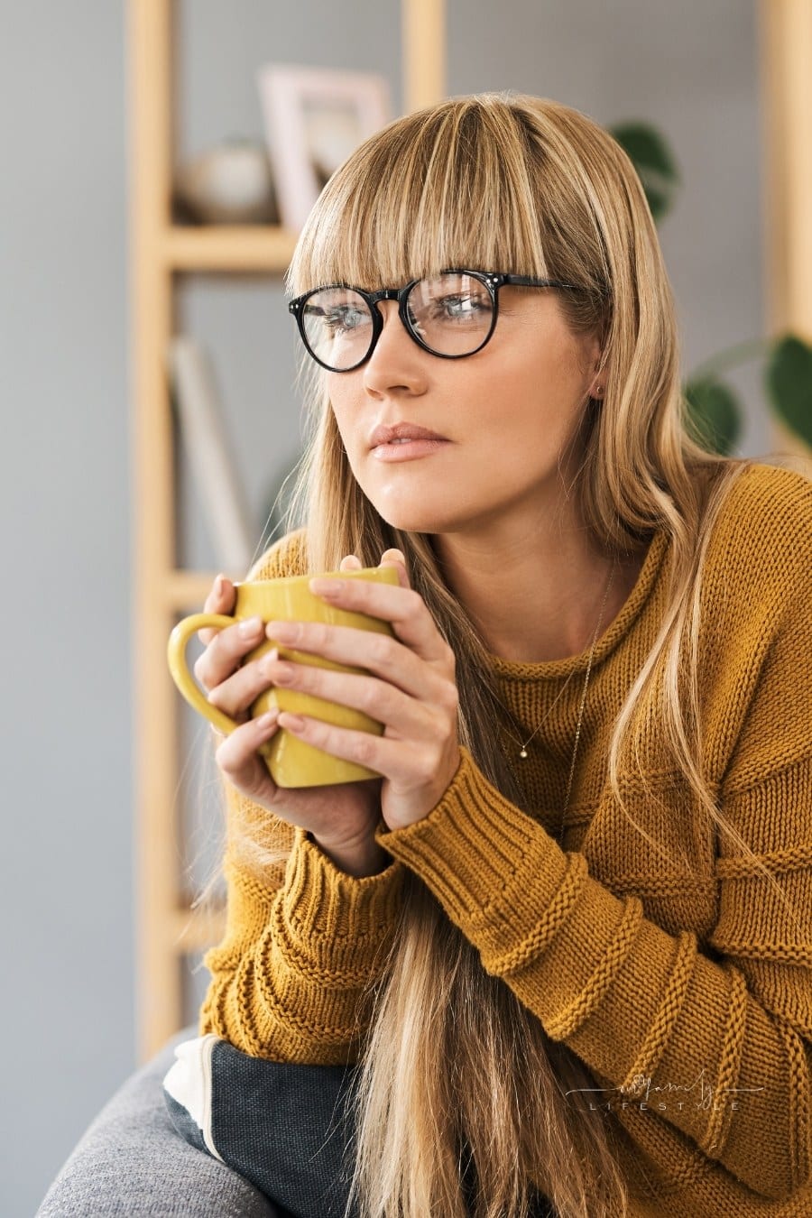 Shot of a young woman having a relaxing coffee break on the sofa at home