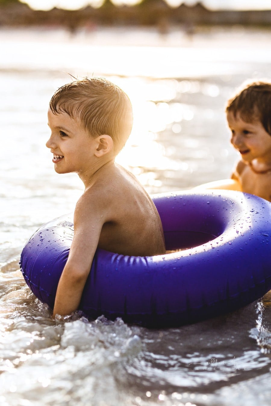 Happy little boys with inflatable rings at sea.