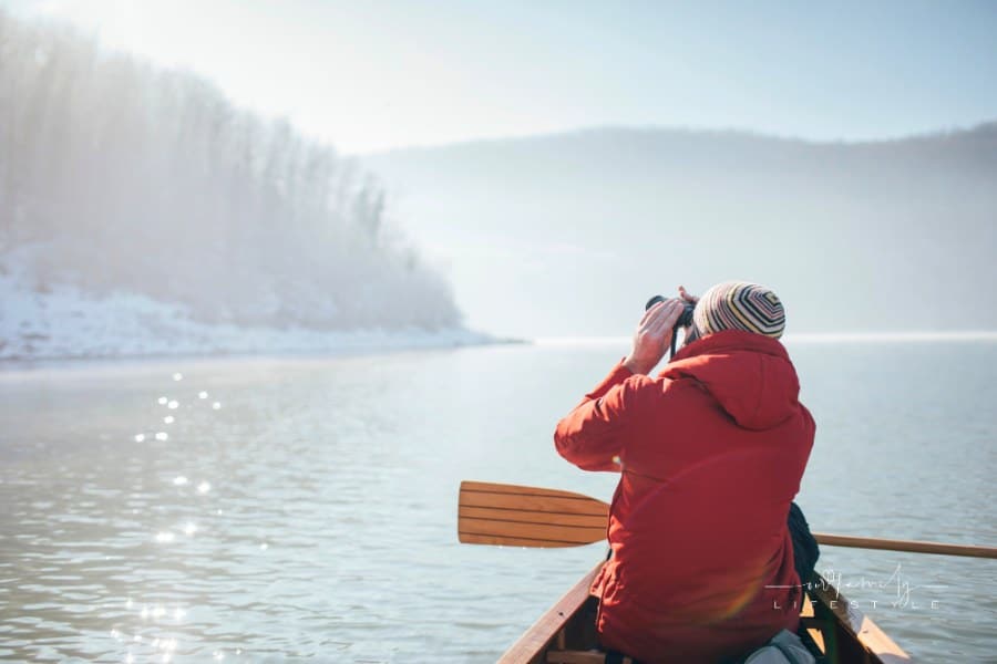 man bird watching from a canoe
