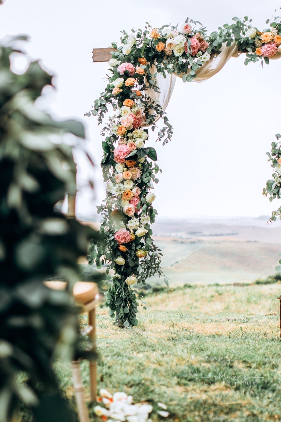 outdoor wedding ceremony with floral arch