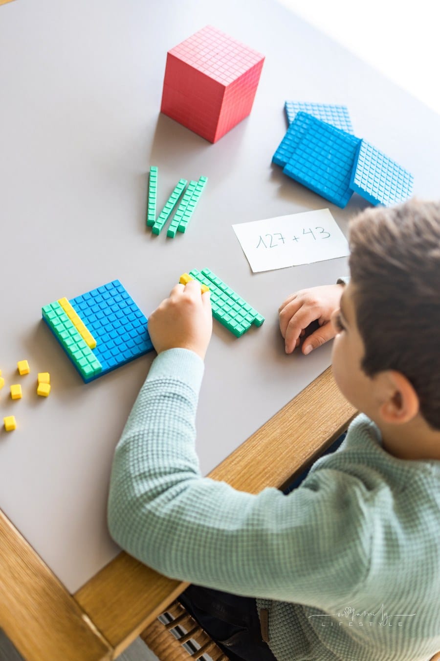 boy using base 10 method to practice math problems