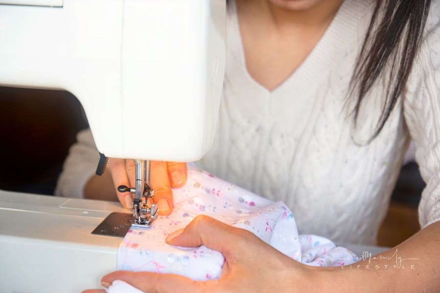 young woman sewing clothes