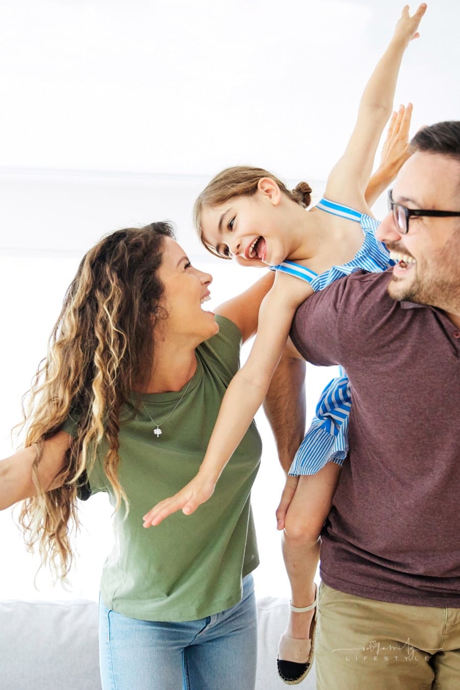 mom and dad playing with daughter at home