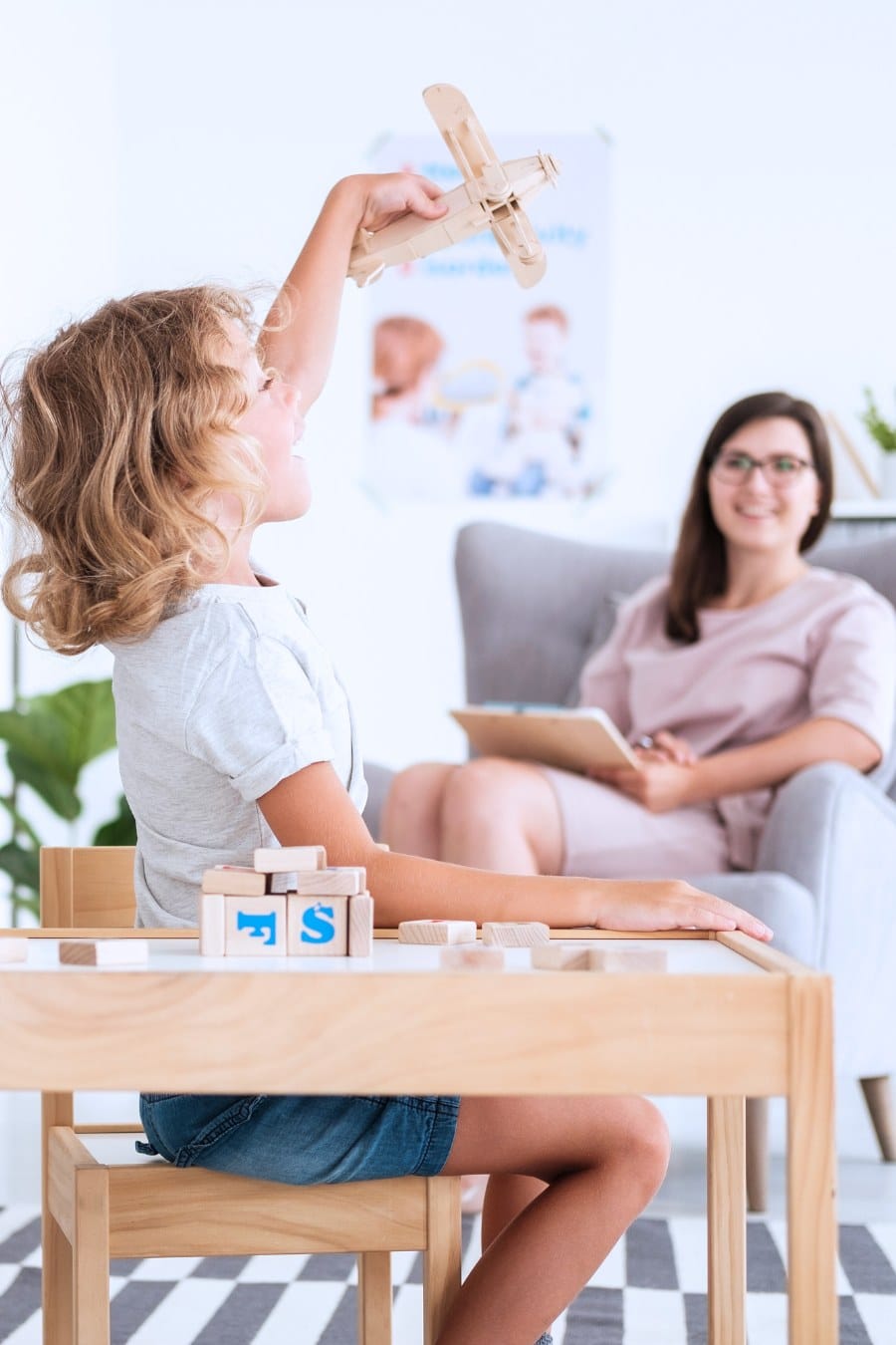 Excited boy playing with a toy plane in a therapist's office