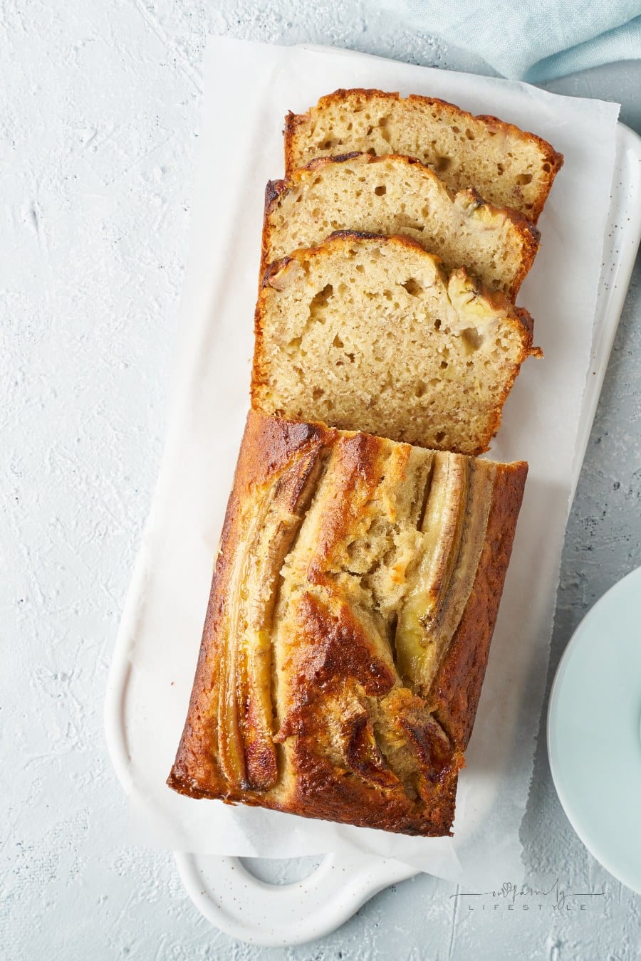 banana bread on a white platter sliced and ready to serve