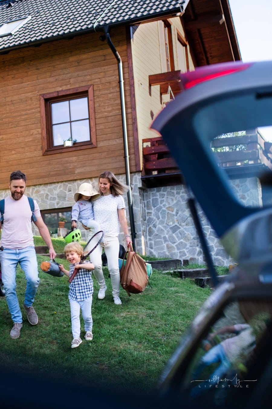 Family with two small children going on cycling trip by car in countryside.