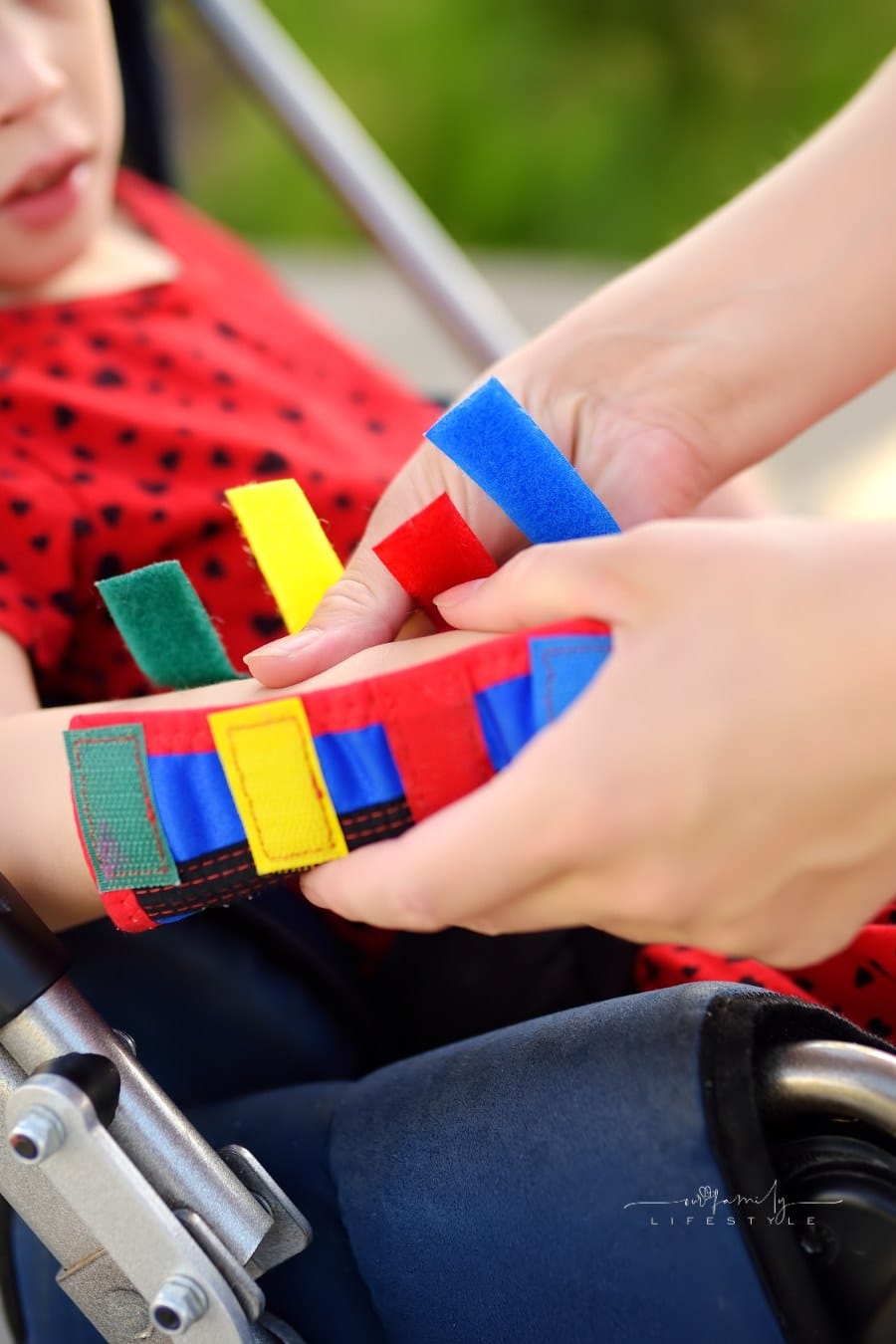 Disabled girl sitting in wheelchair. On her legs orthopedic equipment . Child cerebral palsy. Inclusion. Family with disabled kid.