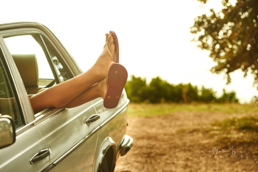 feet wearing flip-flops and hanging feet out of car window