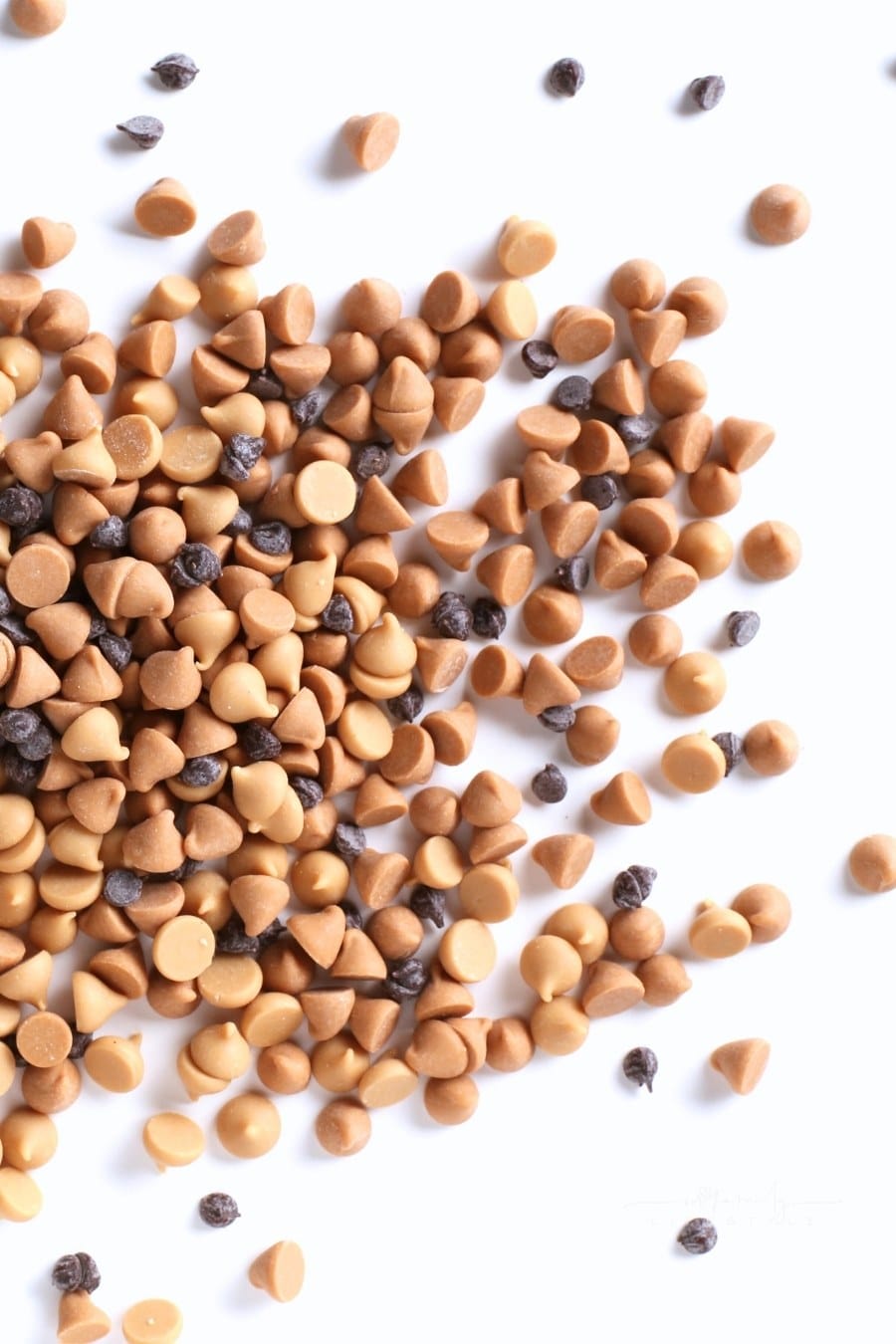 chocolate and peanut butter morsels on white background