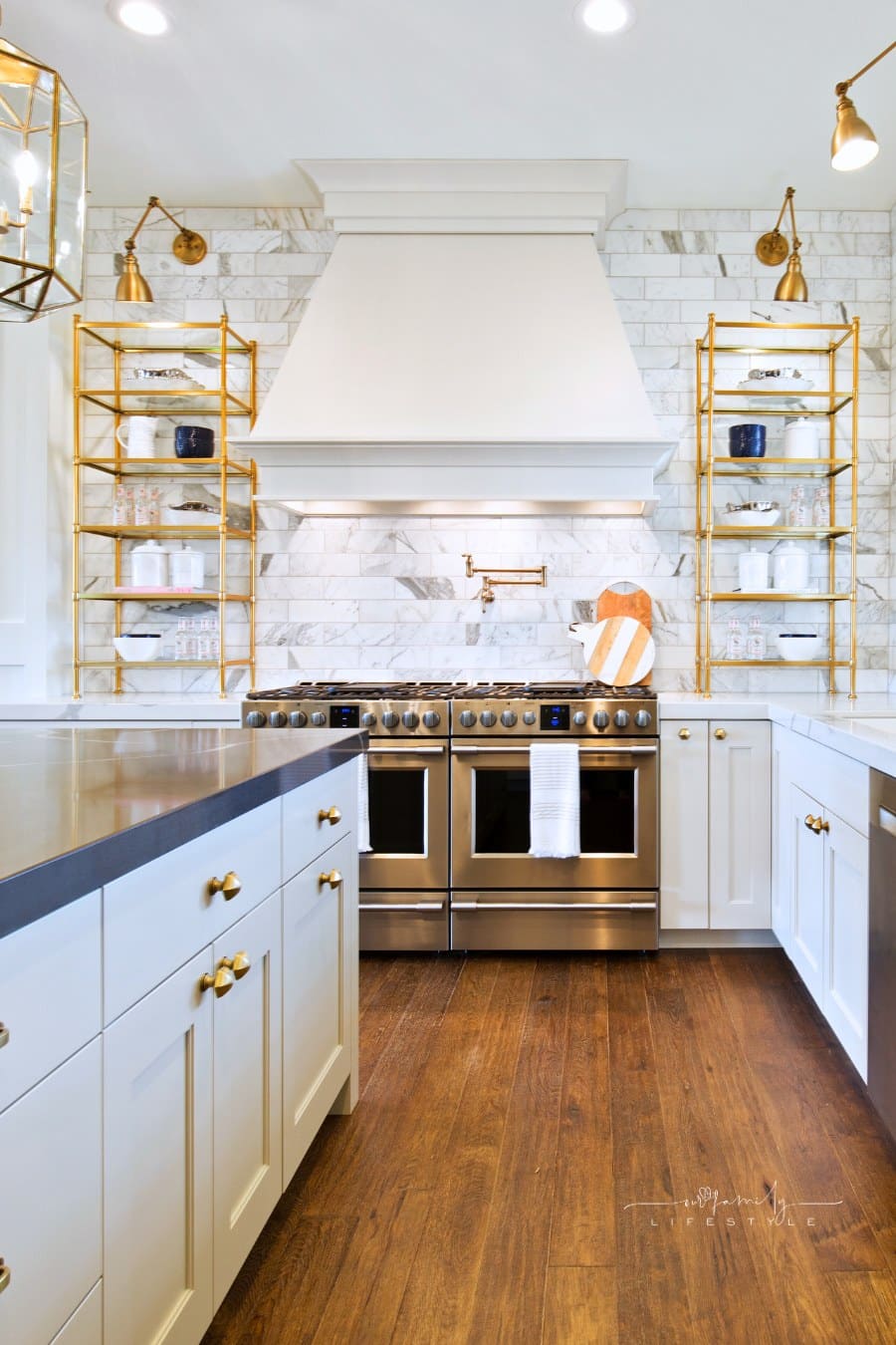 Brass fixtures accompany stainless steel appliances in showcase kitchen