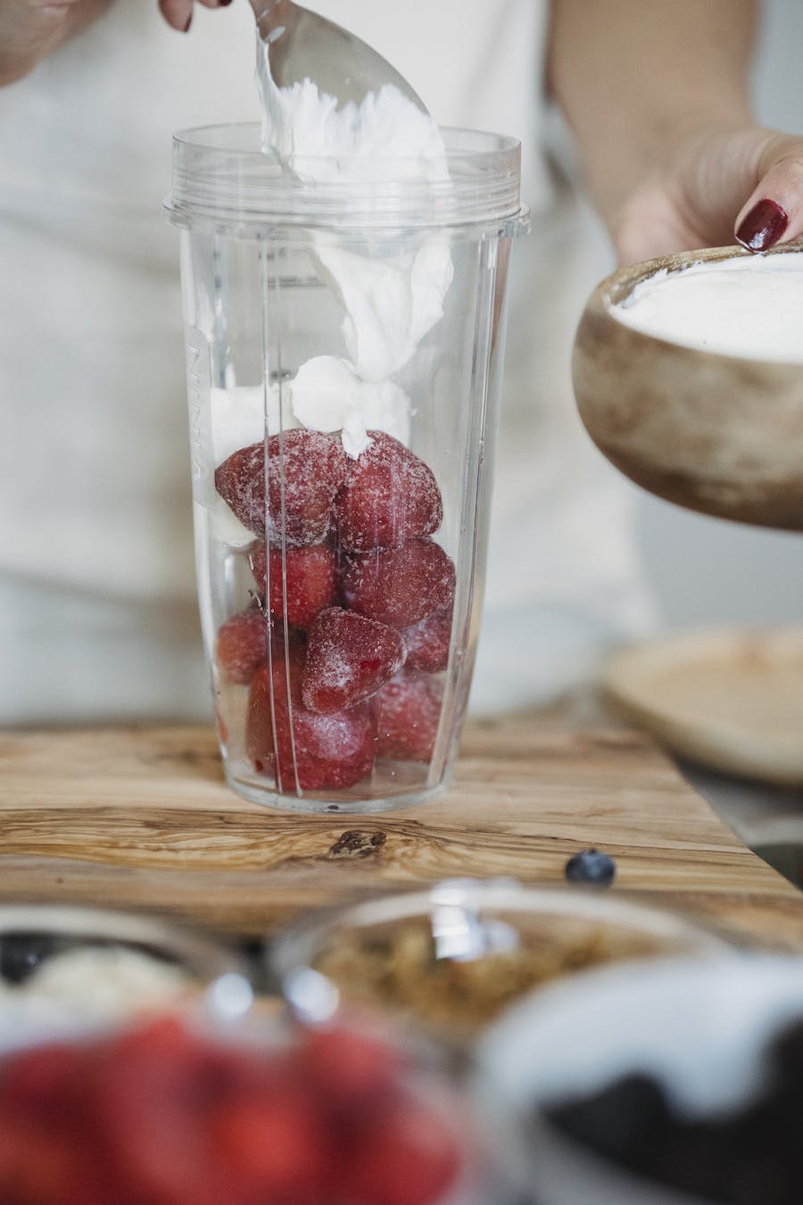 Close-up of strawberries and yogurt in a blender for a smoothie.