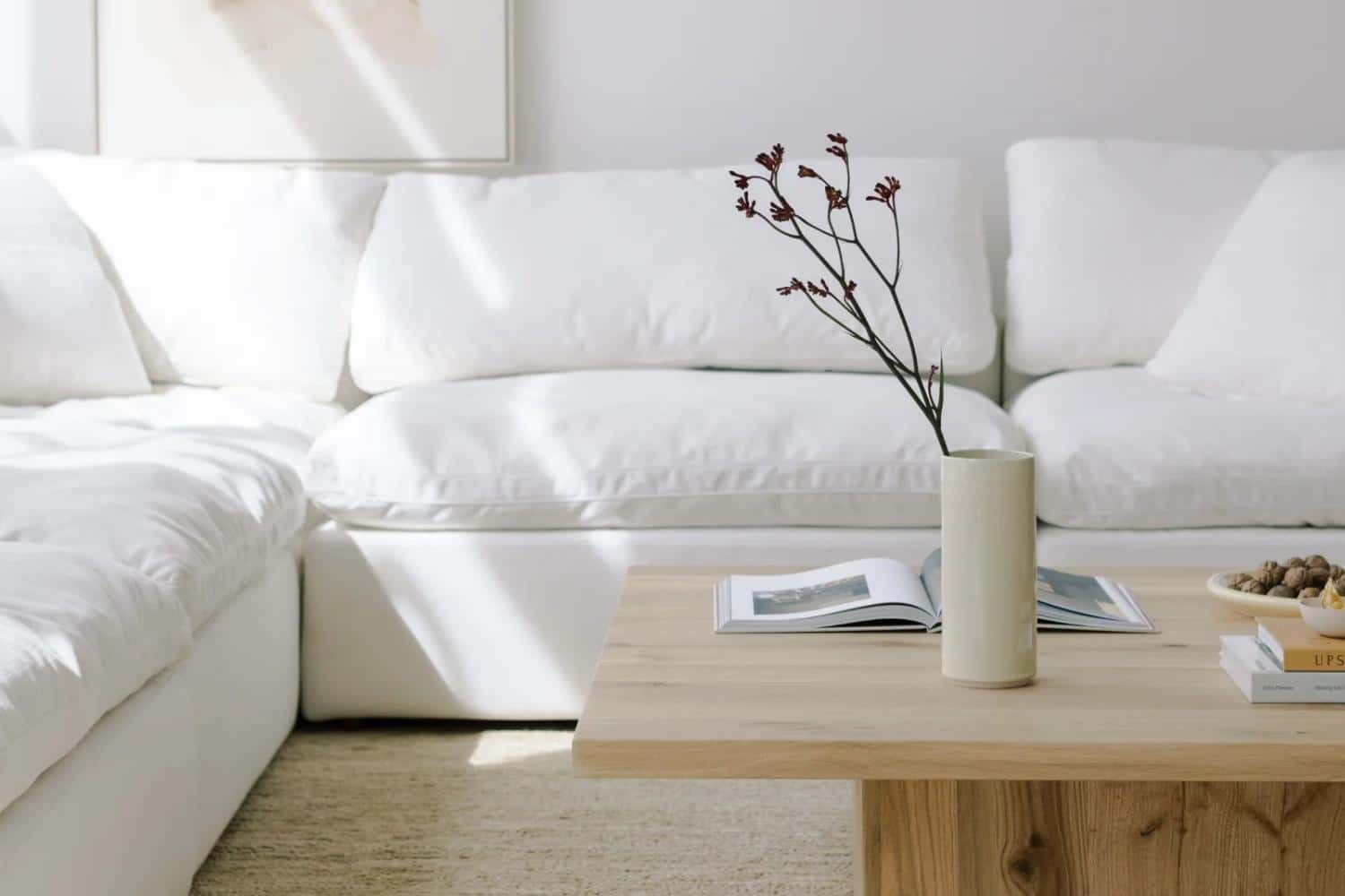 white cloud sofa behind a wooden Scandinavian style table