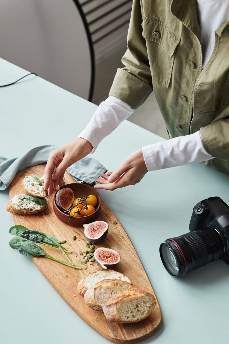 High angle view at female food photographer arranging gourmet dish with props while working in studio, copy space