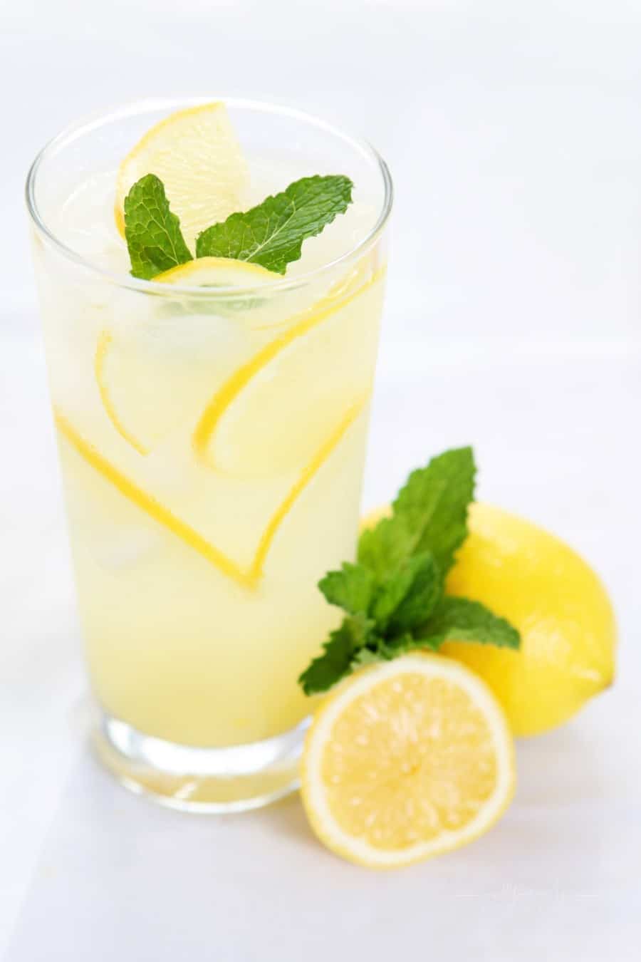 homemade lemonade in a glass with lemon slices on a table
