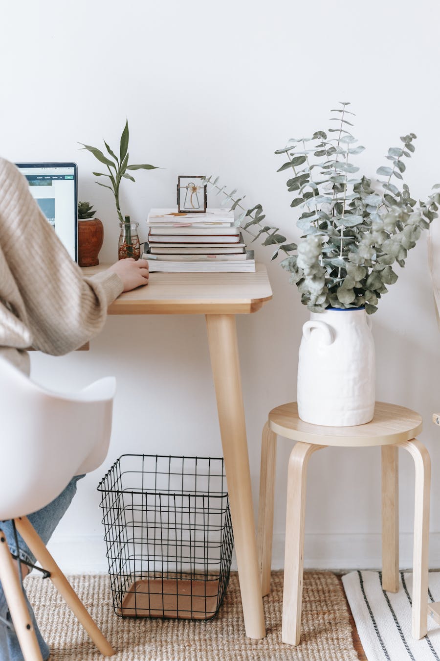 Cozy workspace with a laptop, books, and plants, promoting a relaxed, creative atmosphere.