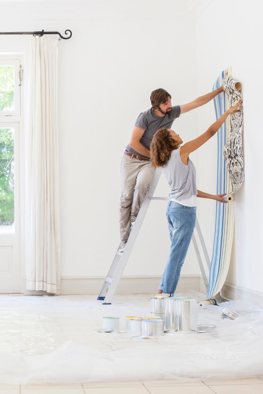 Couple holding wallpaper up to wall to decide on print