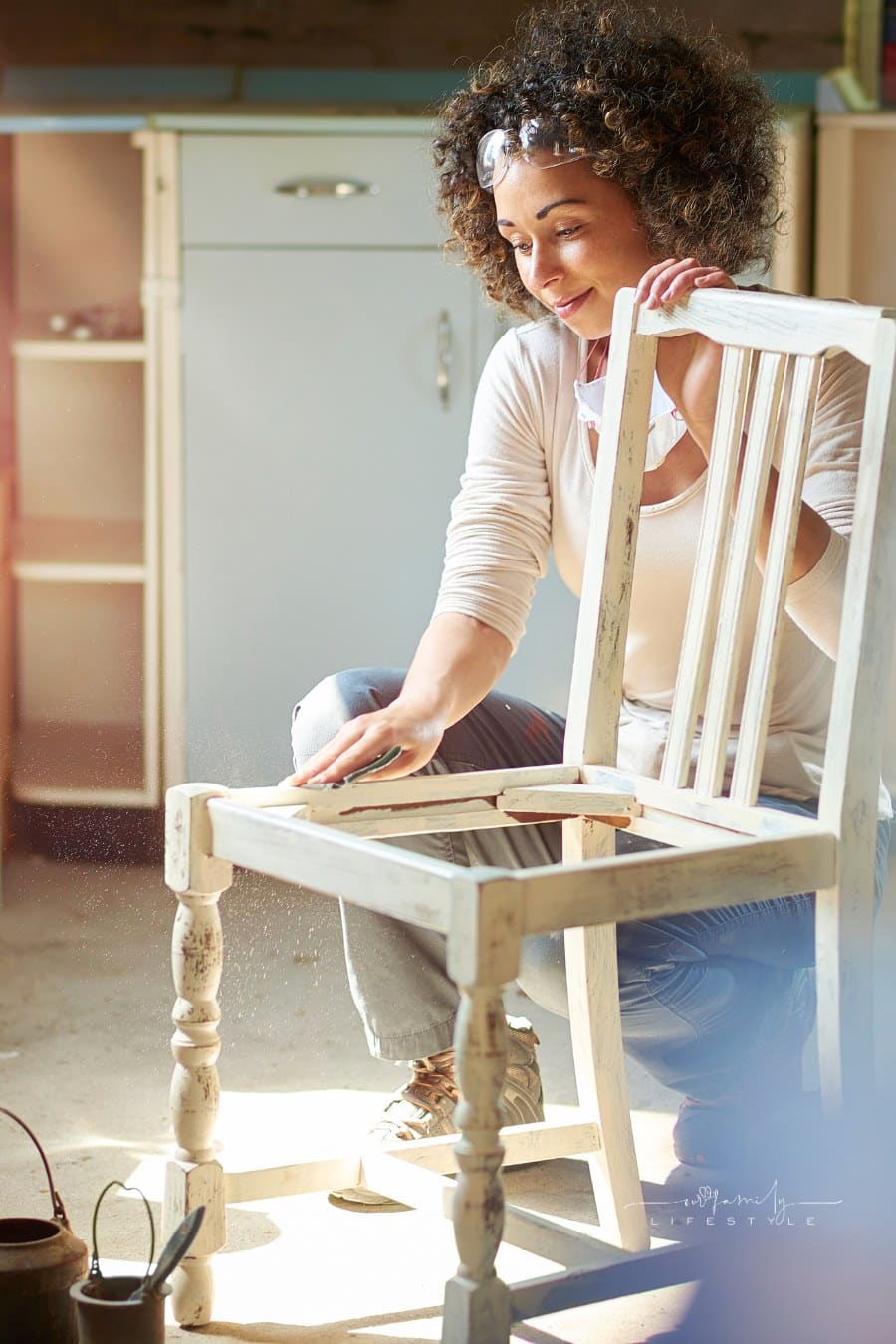 a woman restores and improves an old wooden chair in her workshop