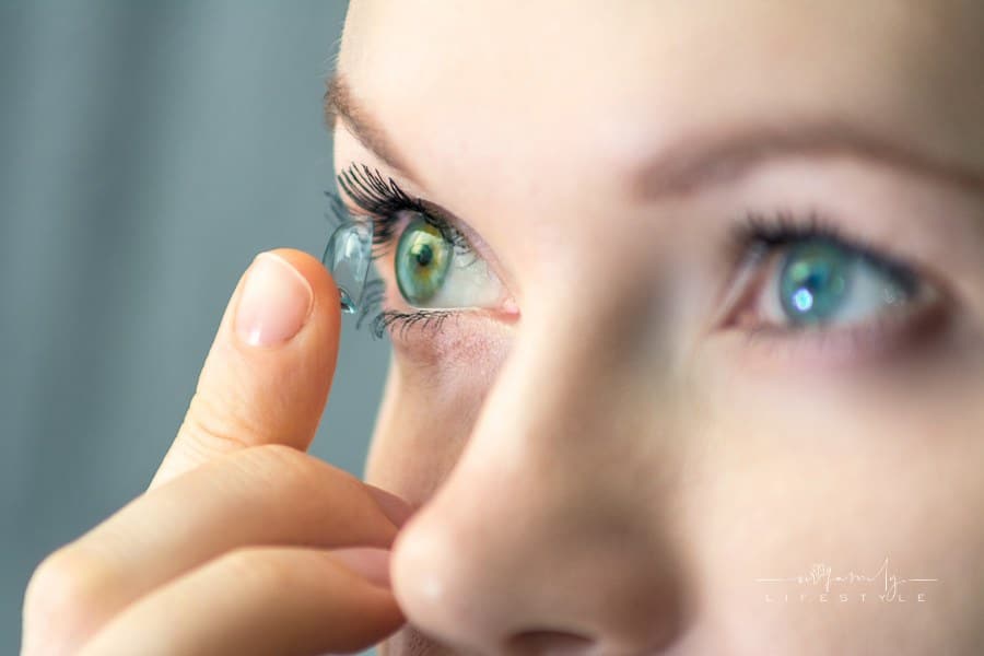 woman putting soft contact lenses into her eye