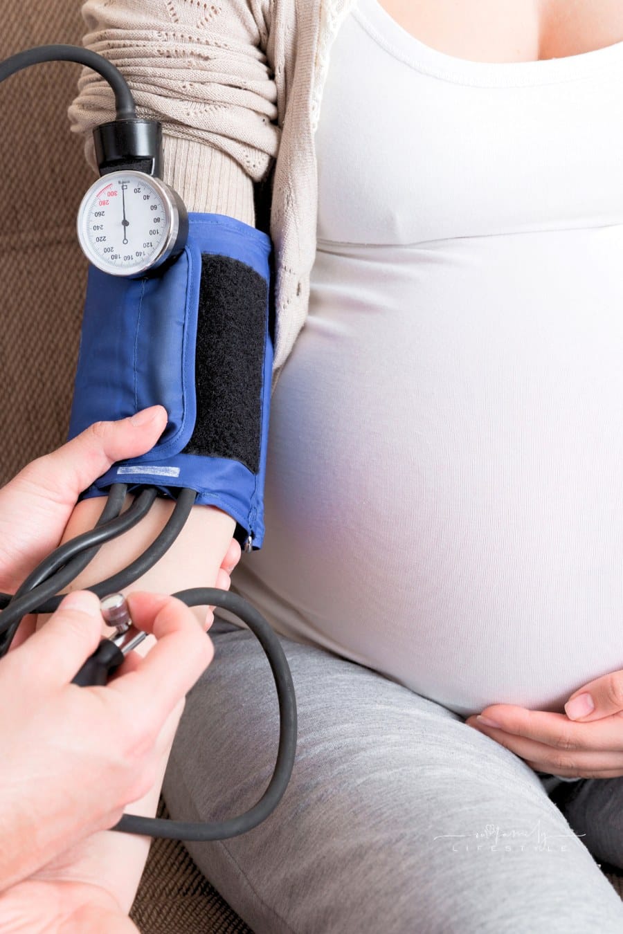 Young Doctor Is Checking Blood Pressure of Pregnant Woman at Home. High Pressure Problem during Pregnancy Concept