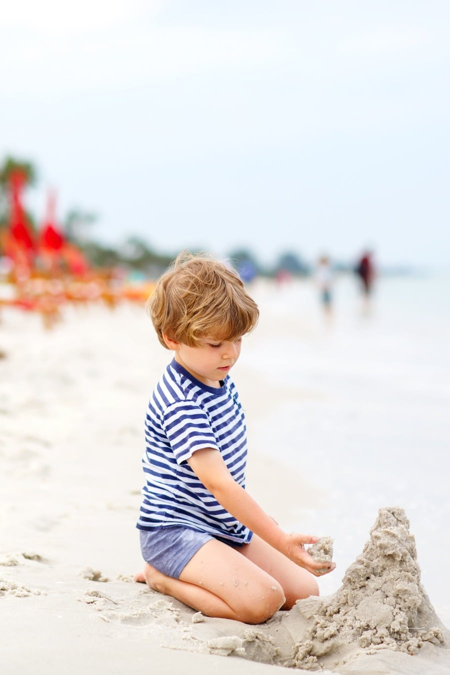boy making sand castle on a beach