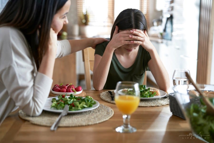 mom comforting teenage daughter with eating disorder