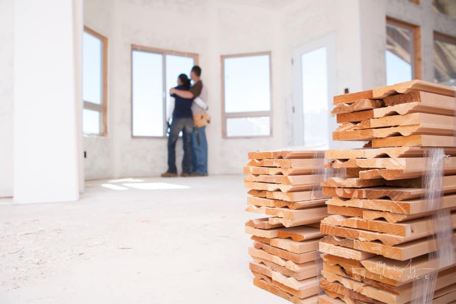 couple looking at window inside new home under construction