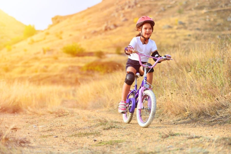 Happy Kid Having Fun in Autumn Park with a Bicycle with full bike gear on

