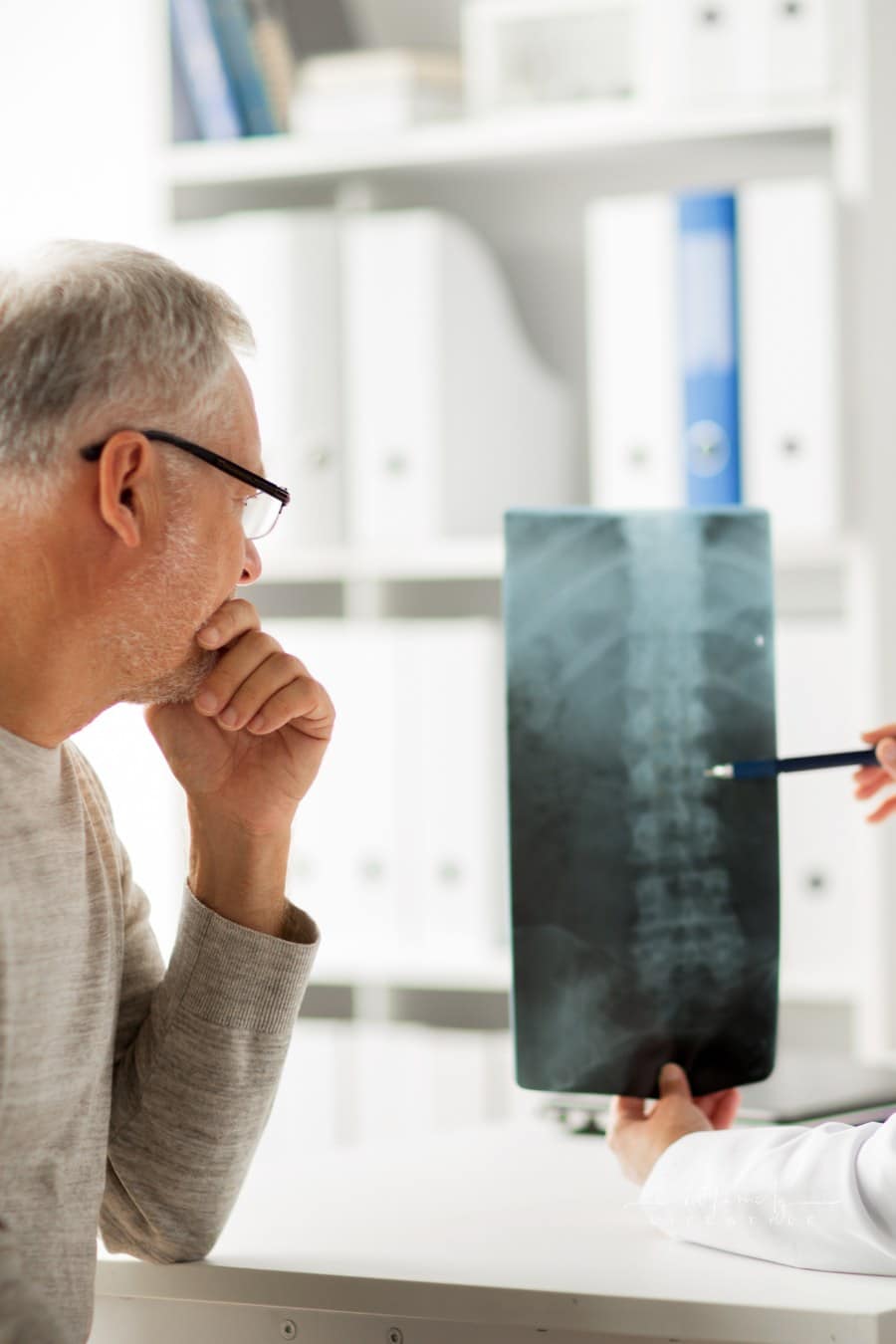 Doctor with Spine X-Ray and Senior Man at Hospital