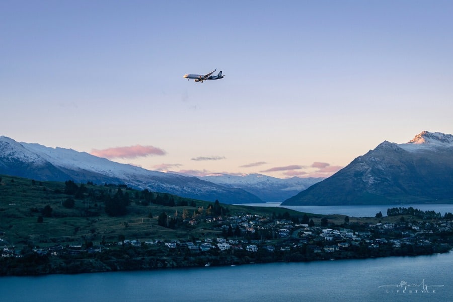 Air NZ plane flying over Lake Wakatipu in Queenstown, South Island, during sunset