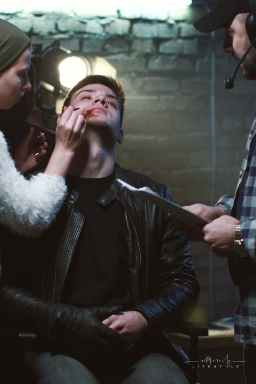 director talking to actor getting makeup on for play