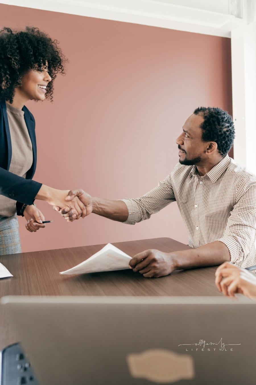 female small business owner shaking hands with male buyer of business