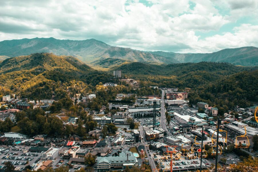 Explore the vibrant cityscape of Pigeon Forge with mountain backdrop from a captivating aerial view.