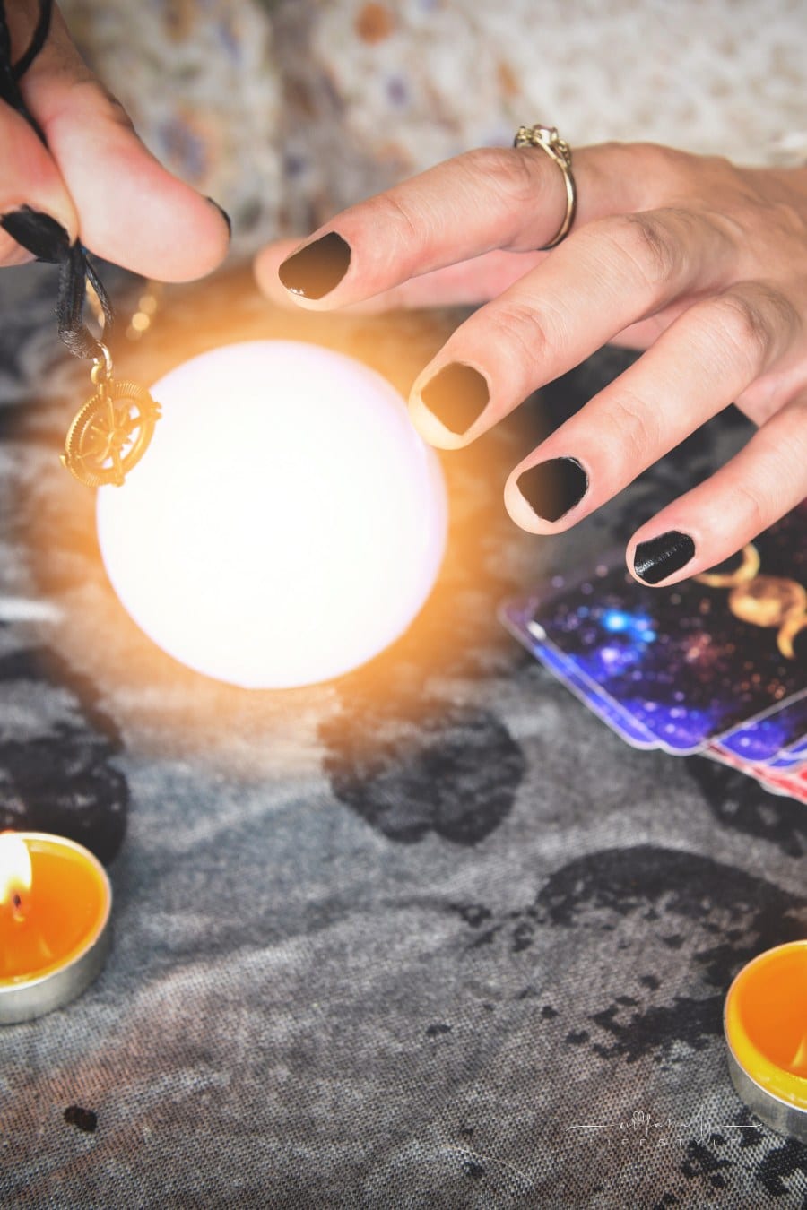 fortune teller's hands hovering over crystal ball