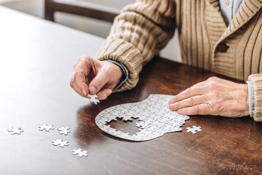 senior dementia patient putting together a puzzle of a head