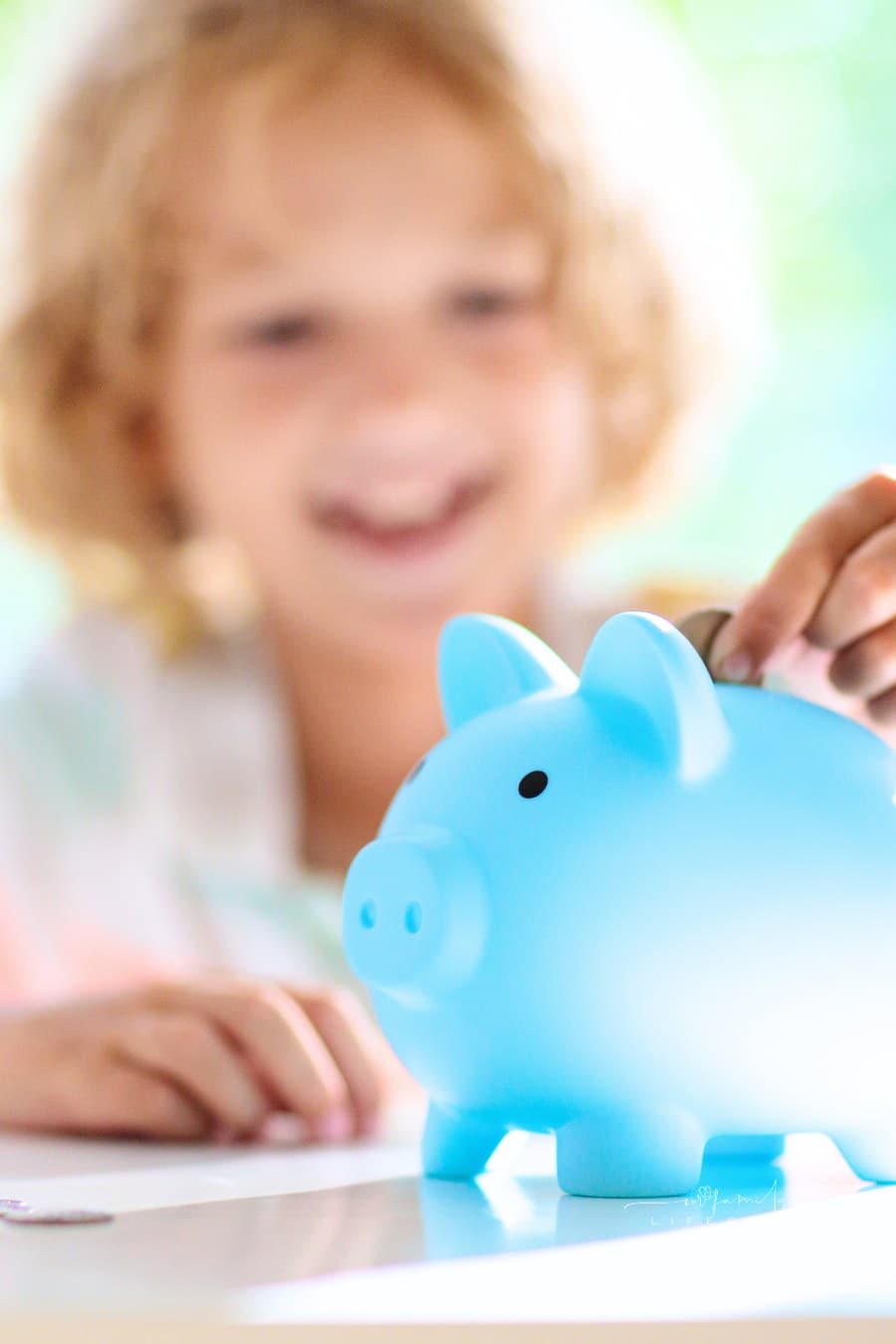 Child putting coin in piggy bank. Kids and money.