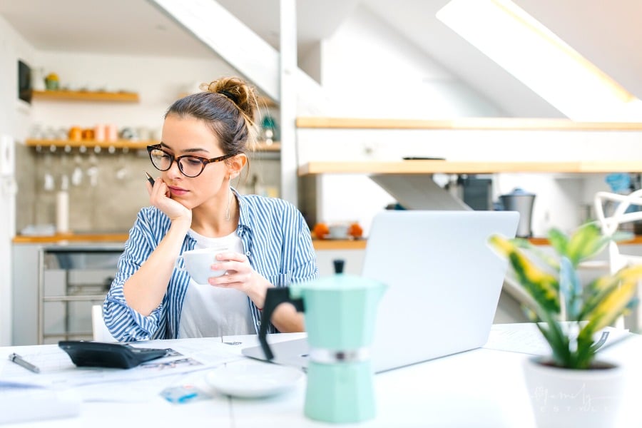 woman working on home budget with coffee in hand