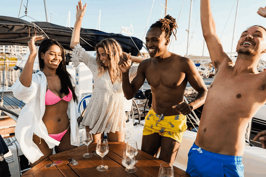 Group of friends celebrating on a boat in a Florida marina, showing the fun and lifestyle benefits of boat club prices and bo