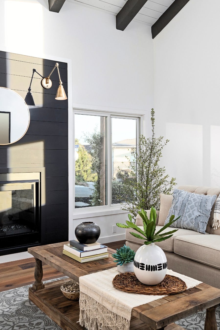 Modern living room with white walls and black shiplap accent fireplace wall