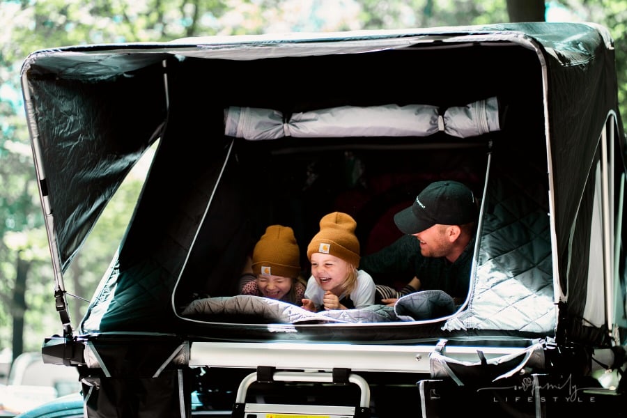 father with kids laughing while inside tent