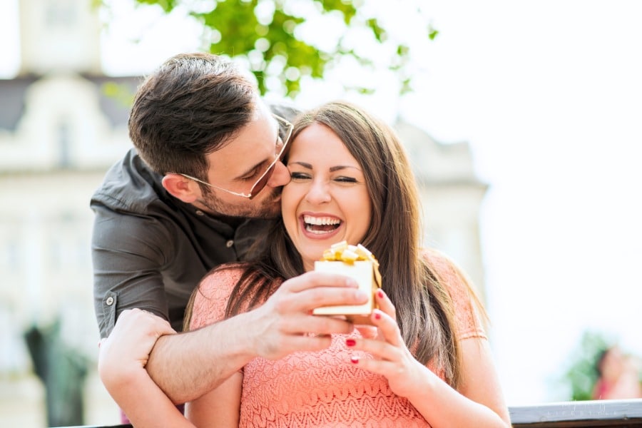husband surprising wife with small gift box