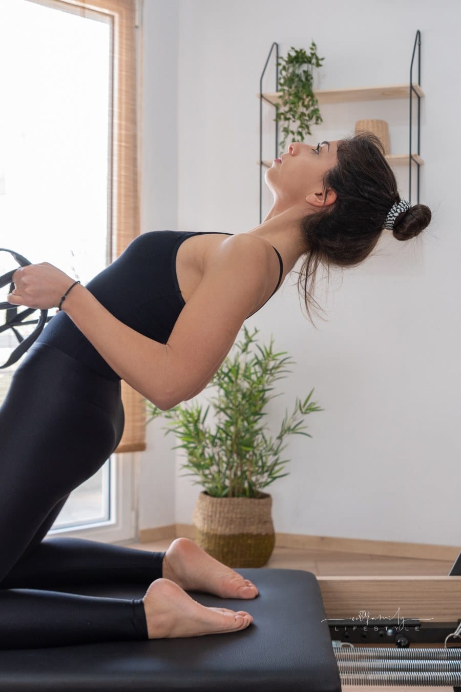 Woman Exercising on Pilates Reformer Bed at home