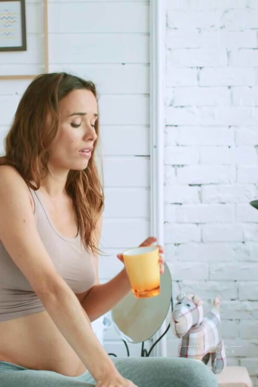 Tired pregnant woman drinking tea in bed to manage nausea. Expectant mother suffering pregnant sick.